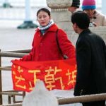 A Falun Gong practitioner holds up a banner saying “Truthfulness, Compassion, Tolerance” in China. (Minghui.org)