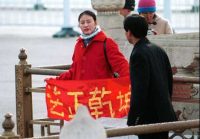 A Falun Gong practitioner holds up a banner saying “Truthfulness, Compassion, Tolerance” in China. (Minghui.org)